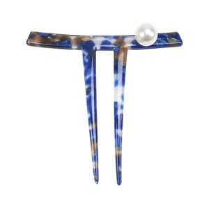Macro detail of acetate hair fork with marble pattern and elegant white pearl accent