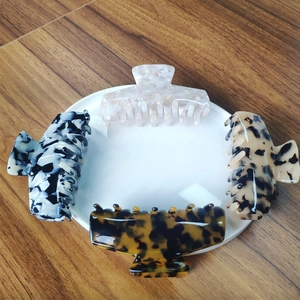 Macro detail of large acetate hair claws in tortoise shell and marble textures