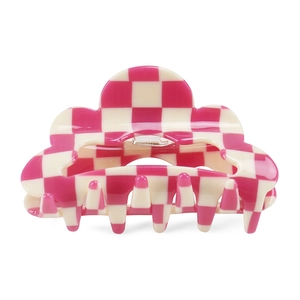 Macro detail of pink checkered claw clip showing cloud-shaped wavy curves and metal spring