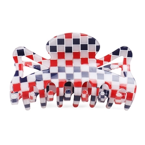 Détail de la grande pince à cheveux en PVC avec motif à carreaux rouge blanc et bleu chic