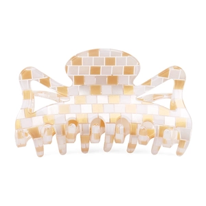 Vue détaillée de la grande pince à cheveux à damier crème et doré au design mosaïque