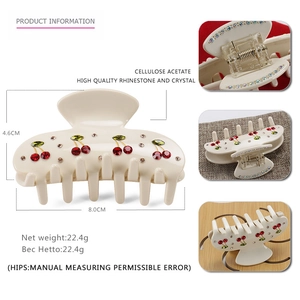 Detail view of cellulose acetate hair claw with cherry rhinestones and size dimensions