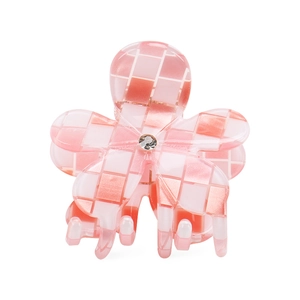 Dettaglio di un fermaglio a fiore a scacchi rosa e bianco con uno strass centrale