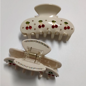 Set of two cream acrylic hair claws with sparkling red cherry rhinestone designs