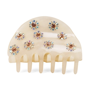 Detail of acrylic hair claw clip with yellow marble texture and rhinestone flower decor