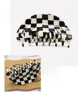 Detail view of large checkered cellulose acetate hair claw clip with glossy finish