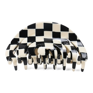 Close-up of a large black and white checkerboard hair claw clip with smooth finish