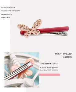Dettaglio del fermaglio per capelli in acetato rosa con farfalla di strass e clip in metallo