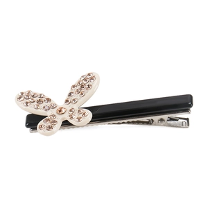 Dettaglio della molletta francese a fiocco con strass brillanti e design in acetato crema