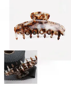 Detailed macro view of acetate hair claw clip with rhinestones and tortoiseshell texture