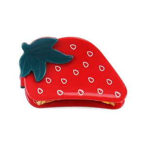 Detail of red strawberry hair claw clip made of acrylic with golden metal spring