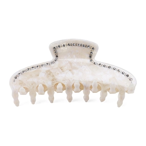 Detail of cream acetate shark hair claw clip with rhinestones and marble texture