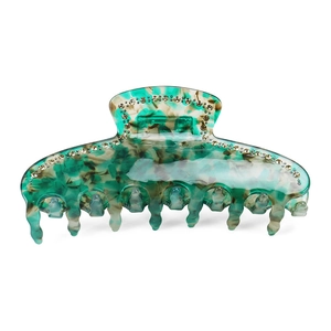 Detail of large acetate hair claw clip with marble texture and sparkling rhinestones