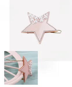 Detail view of the star-shaped acetate hair clip with pearls and silver accents