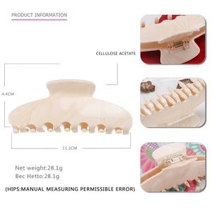 Detail view of large cream marble acetate hair claw clip showing 11.2cm size and weight