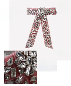 Detailed close-up of pink velvet bow hair clip with multi-shaped rhinestones and size labels
