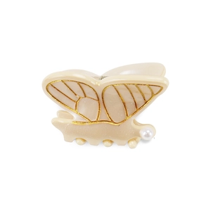 Pince à cheveux papillon en acétate avec accents dorés et perle sur fond blanc