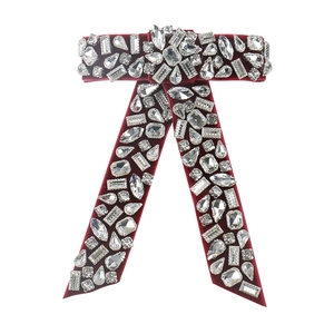 Detailed macro shot of vintage red velvet bow hair clip with sparkling crystal inlay