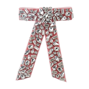 Detailed view of pink velvet bow hair clip with sparkling multi-shape crystals