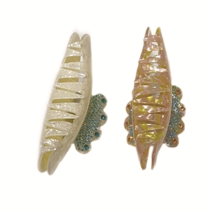 Large acetate hair claws with marble patterns and rhinestones on a white background