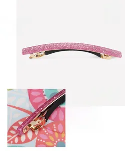 Pink glitter acrylic hair clip with spring mechanism and golden base details