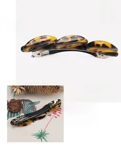 Detail view of cellulose acetate hair clip showing tortoise shell pattern and metal spring
