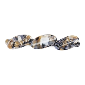 Macro view of French acetate spring hair clip showing marble texture and oval geometry