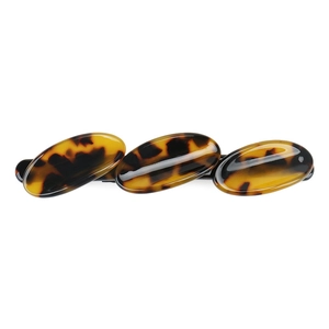 Detailed close-up of French acetate hair clip with tortoiseshell pattern and geometric design