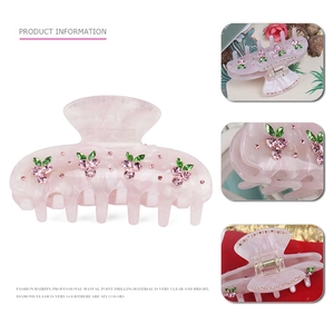 Detail view of pink acetate hair claw clip with rhinestones cherry and marble texture