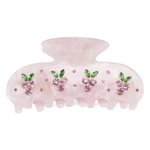 Detailed view of pink acetate hair claw with sparkling rhinestone cherry embellishments