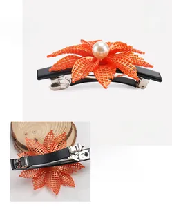 Detailed view of orange acetate flower hair clip with pearl center and 8.5cm spring clip