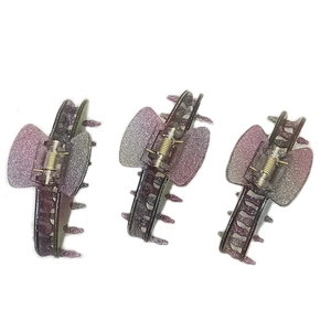 Three purple gradient glitter acrylic hair claws with butterfly shape in a detailed row