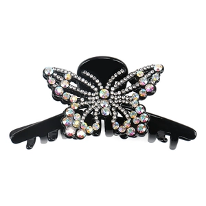 Détail macro de la pince à cheveux papillon avec des strass étincelants sur noir
