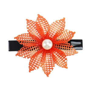 Detail view of orange floral hair clip with hollow petals and white pearl center