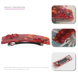 Red acetate hair claw with crystal flower detail and spring clip for ponytail styling