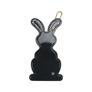 Close-up of black rabbit hair clip with sparkling crystal edges and golden metal fastener