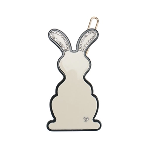Close-up of white rabbit hair clip with rhinestones and golden U-shaped metal pin