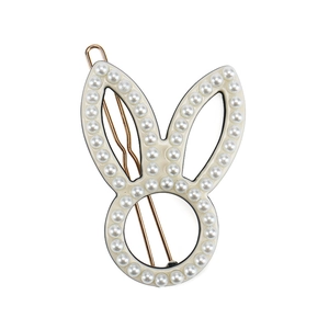 Detail view of acetate bunny hair clip with pearl trim and gold-plated metal base