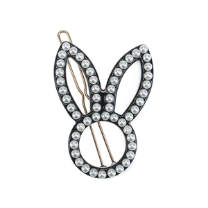 Detail of bunny ear hair clip with faux pearl inlay and gold metal clip base