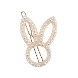 Detailed macro view of white rabbit ear hair clip with pearls and metal fastener