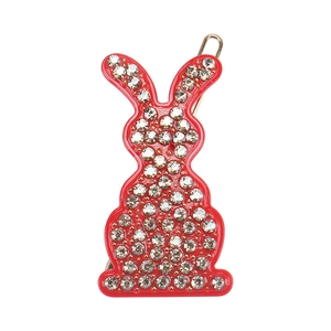 Détail d'une barrette lapin rouge avec des strass brillants et un clip en métal doré