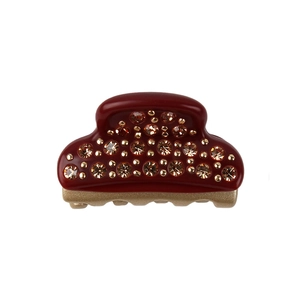 Macro view of a small wine red acetate hair claw clip with champagne rhinestones
