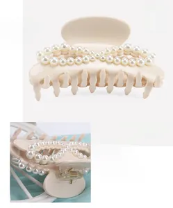 Detailed view of cream acetate hair claw clip with pearl infinity design and 5x9cm size