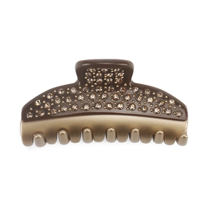 Macro view of French luxury large hair claw with champagne crystals and golden metal teeth