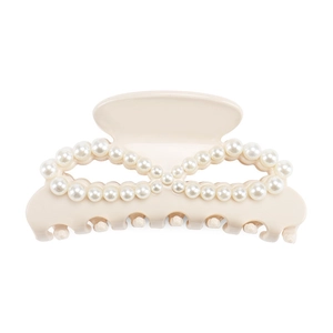 Detailed view of beige hair claw clip with elegant infinity pearl arrangement