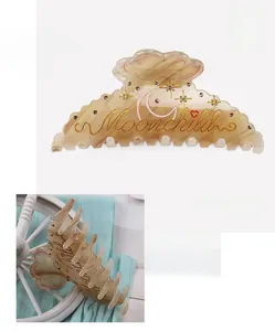 Detailed size view of an amber patterned acetate shark hair clip with Moonchild engraving