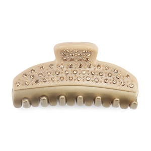 Macro detail of luxury beige resin hair claw clip with champagne crystals and gold teeth