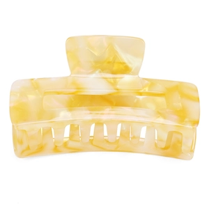 Detail view of square acetate hair claw with cream and white marble texture on white background