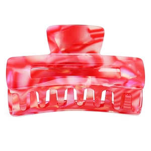 Macro detail of red and pink marble acetate hair claw showing pearlescent texture