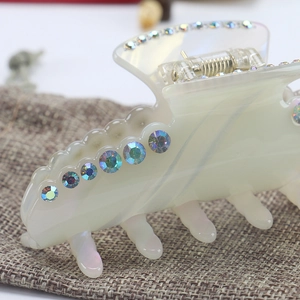 Elegant cream white acetate hair claw clip with iridescent rhinestones and wavy design